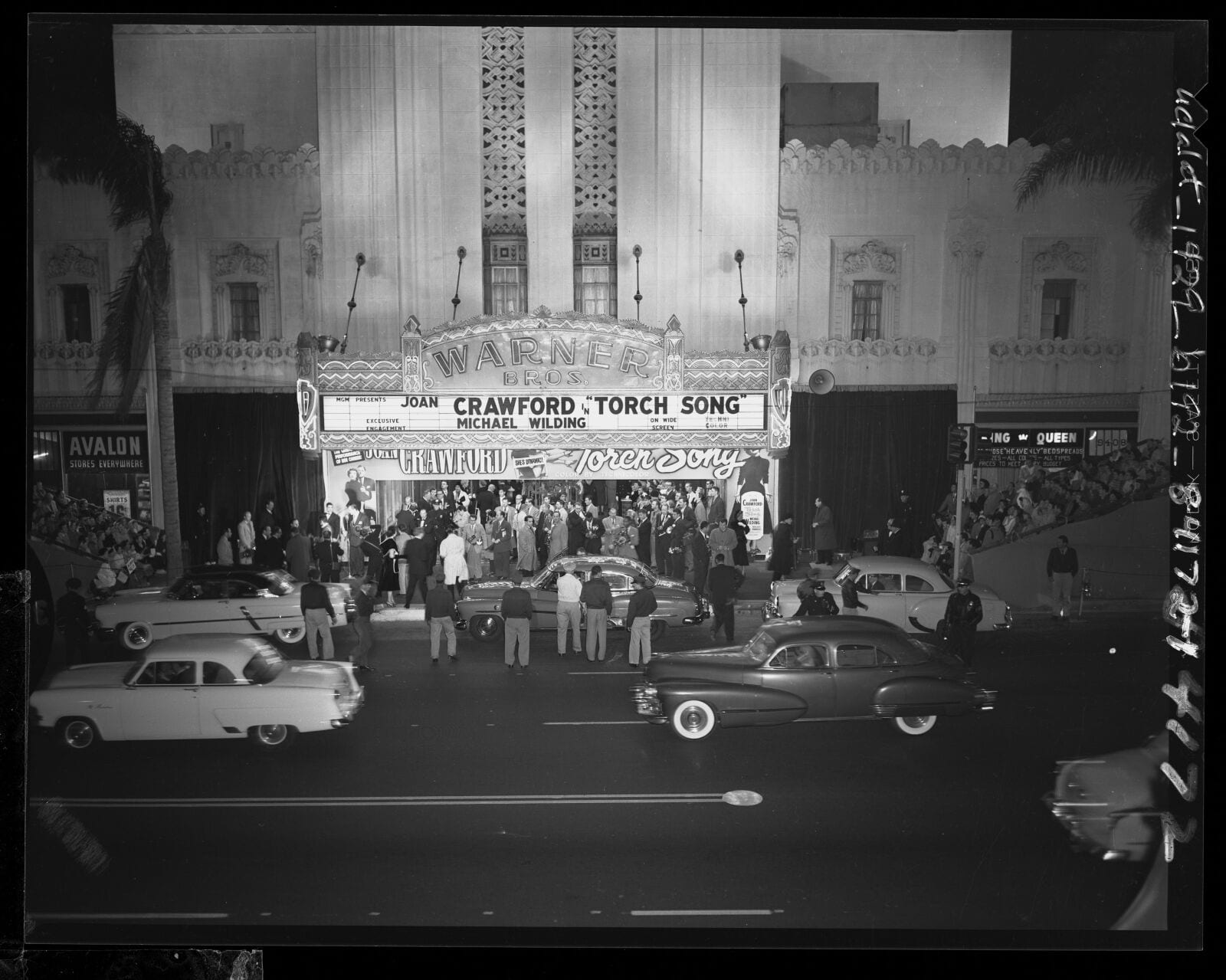 Automobiles passing by crowds outside Warner Bros. Theater for the "Torch Song" movie premiere in Los Angeles, Calif., 1953, 1953, Los Angeles