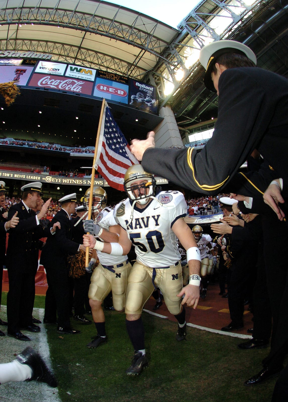 US Navy 031230-N-6213R-002 Navy linebacker Ben Mathews leads his teammates on to the field prior to the Midshipmen's tilt with Texas Tech in the EV1.Net Houston Bowl at Reliant Stadium in Houston, Te…, 2003, Houston