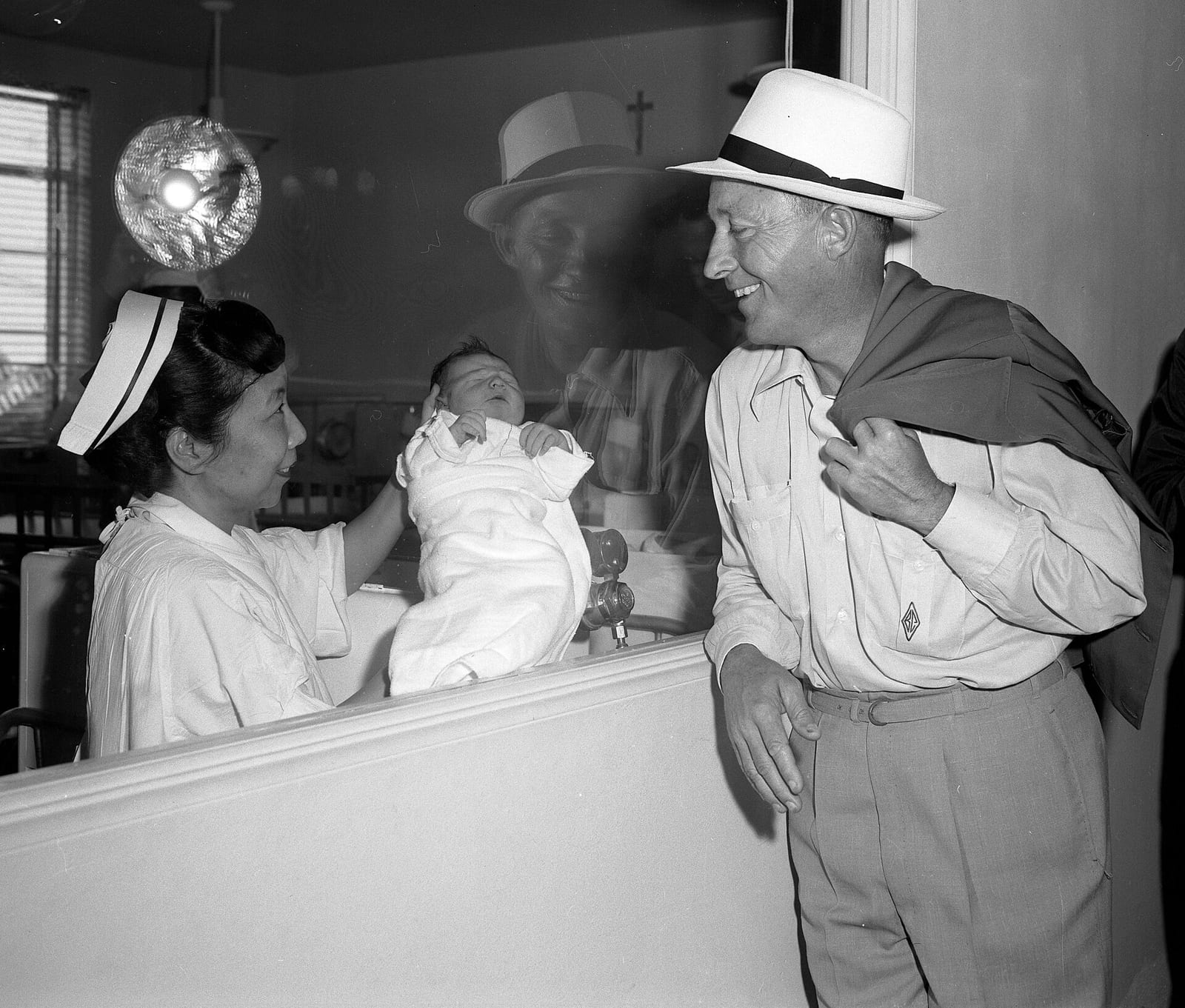 Bing Crosby looking at his newborn son Harry in the nursery of a Los Angeles hospital, 1958, Los Angeles